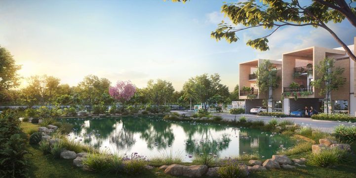 Scenic view of a lush green landscape with a lake, trees, and modern villas in the background at Allure Avani